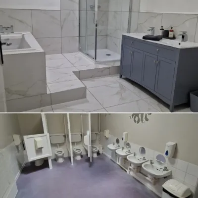 Marble-tiled bathroom renovation with glass shower enclosure and blue vanity unit