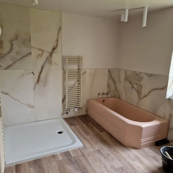 Bathroom renovation with marble-effect large format wall tiles and heated towel rail