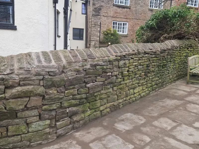 Traditional stone boundary wall with coping stones in a Cheshire village