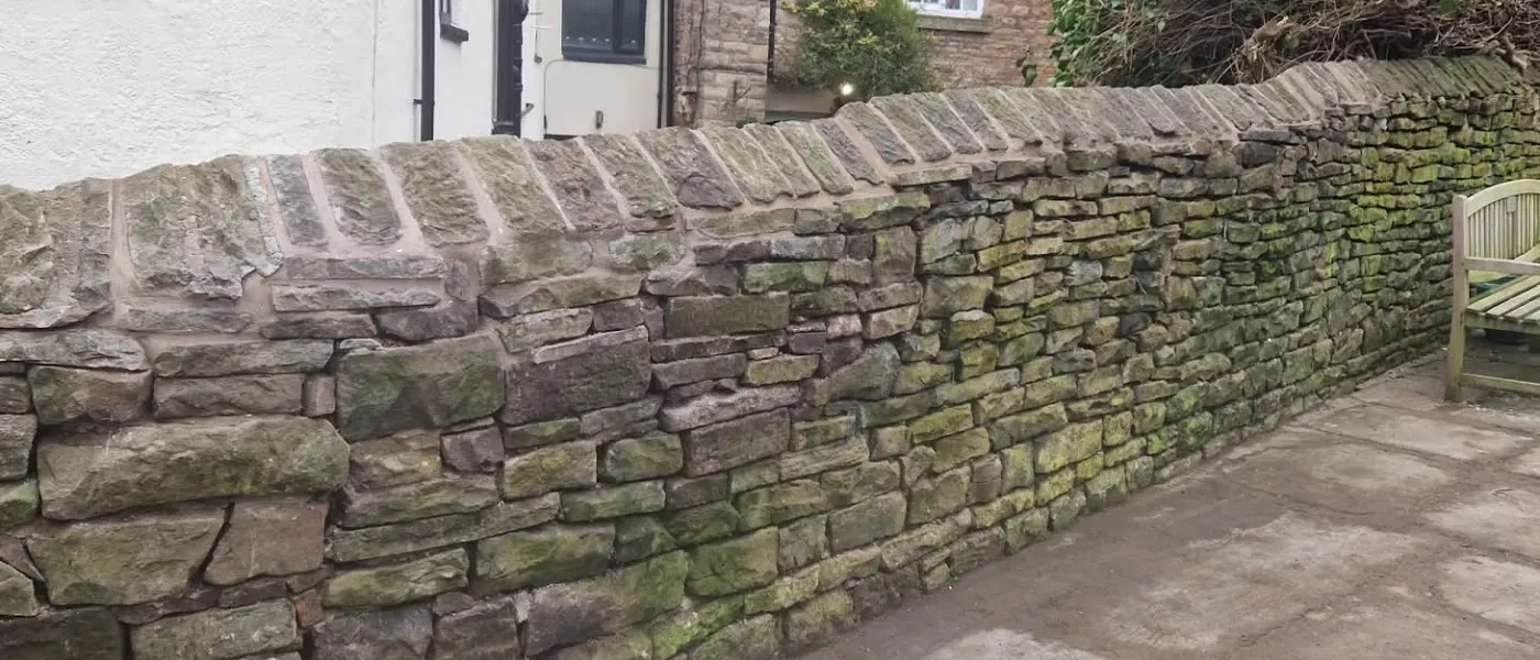 Traditional stone boundary wall with coping stones in a Cheshire village